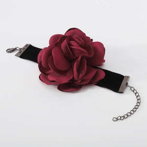 Détail du choker rose en tissu rouge foncé avec ruban en velours noir et chaîne réglable