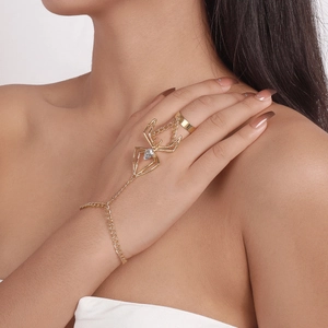 Macro shot of gold spider slave bracelet with teardrop zircon on woman's hand