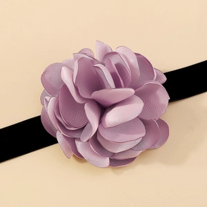 Détail d'un ras de cou fleur en tissu lavande avec ruban de velours noir élégant