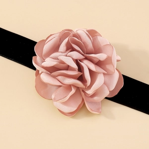 Détails des pétales de fleurs en tissu rose superposés et du tour de cou noir élégant