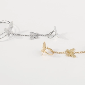 Detail of silver and gold butterfly slave bracelets with intricate filigree texture