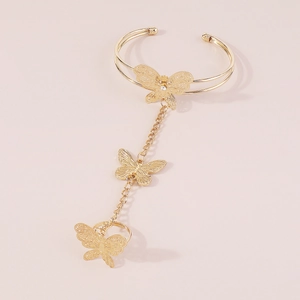 Detail of a golden butterfly slave bracelet featuring hollow wings and delicate chain link