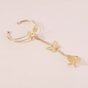 Detailed view of golden butterfly bracelet-ring set with hollow wings and rhinestones