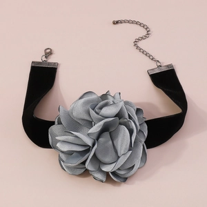 Détail d'un ras de cou avec une grande rose grise en tissu et ruban de velours noir avec fermoir