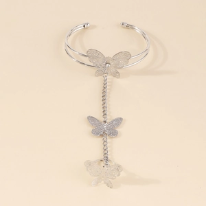 Macro detail of silver butterfly hand chain with intricate cut-out wing patterns