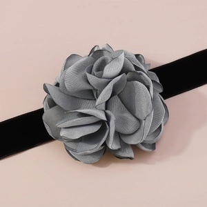 Détail d'une fleur en tissu gris faite main sur un ruban tour de cou en velours noir