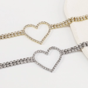 Close-up of gold and silver heart-shaped necklaces with sparkling rhinestones in detail