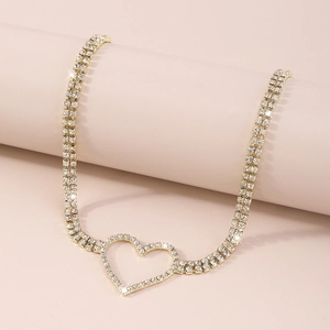 Detail of a double-row gold necklace featuring a hollow heart pendant and sparkling rhinestones