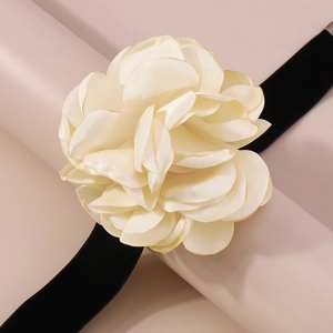 Gros plan du tour de cou élégant avec rose en tissu crème et ruban de velours noir