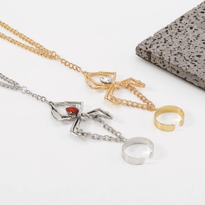 Gothic gold spider hand chain featuring a sparkling white rhinestone on a metal web