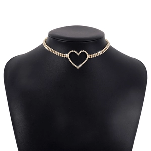 Macro view of gold choker necklace featuring a double-row rhinestone band and heart pendant