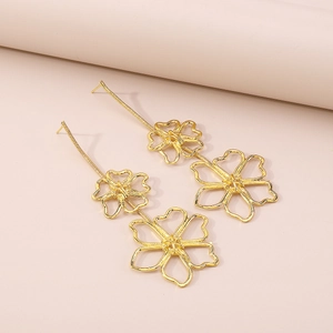 Macro view of elegant double layered hollow floral drop earrings in polished gold alloy