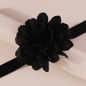 Gros plan d'un élégant ras du cou fleur en tissu noir avec des pétales superposés raffinés