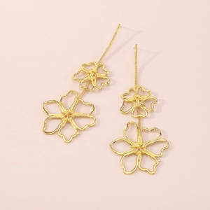 Macro detail of vintage gold flower earrings with delicate metal wire wrapping texture