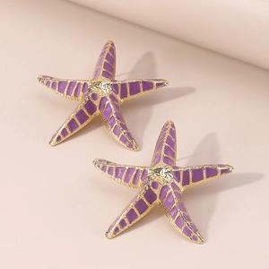 Détail des boucles d'oreilles étoile de mer dorées avec émail violet et motif à carreaux