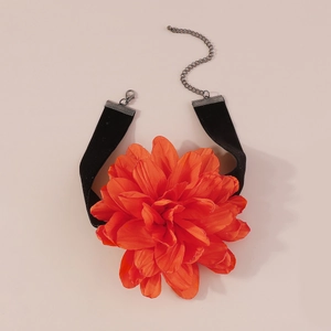 Détail macro d'un choker fleur orange en tissu avec ruban de velours noir élégant