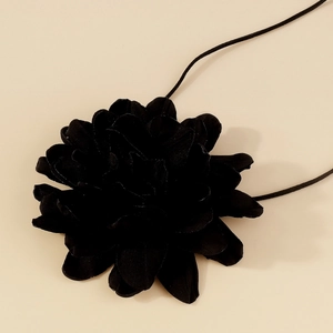 Gros plan d'un choker rose en velours noir avec texture de pétales élégants et cordon fin