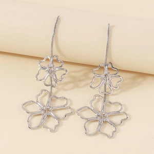 Vintage silver alloy hollow flower drop earrings with chic snake chains on pink background