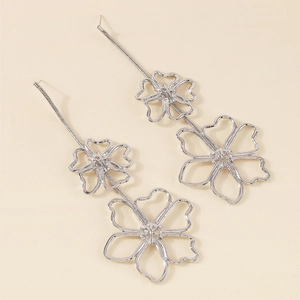 Detail of silver long drop earrings featuring hollow minimalist floral outlines