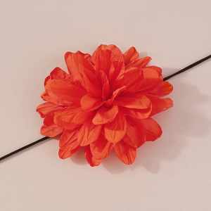 Détail macro du choker fleur en tissu orange avec des pétales texturés multicouches