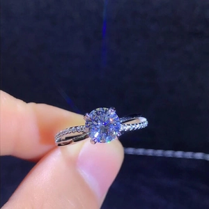 Silver four-prong cross open ring featuring a brilliant round-cut moissanite stone