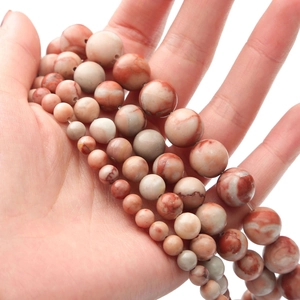 Macro shot of natural red marble beads in various sizes for DIY jewelry making