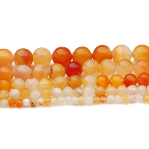 Vista dettagliata di perle tonde in agata arancione naturale lucida in varie dimensioni