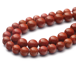 Makroaufnahme polierter roter Jaspisperlen mit Natursteintextur für DIY-Schmuck
