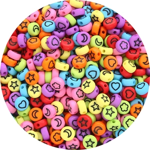 Macro shot of matte acrylic flat beads with star and moon patterns for DIY jewelry