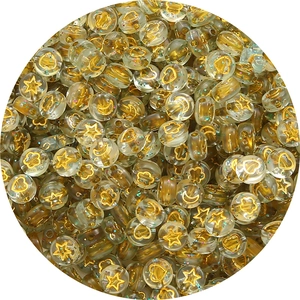 Macro detail of transparent acrylic round beads with gold stars moons and colorful sequins