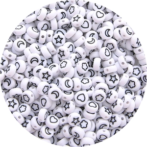 Detailed macro view of white acrylic star and moon pattern flat round beads for DIY jewelry
