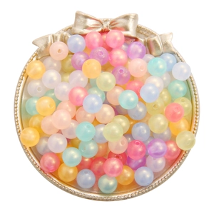Colorful macaron acrylic beads for DIY jewelry making displayed in a golden tray