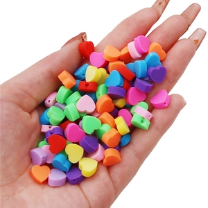 Handheld view of colorful heart-shaped acrylic beads for DIY jewelry making and crafts