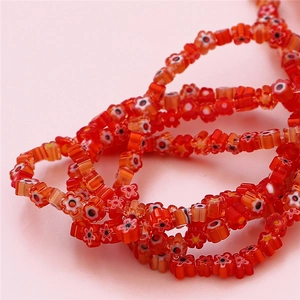 Détail macro de perles en verre millefiori rouges pour création de bijoux