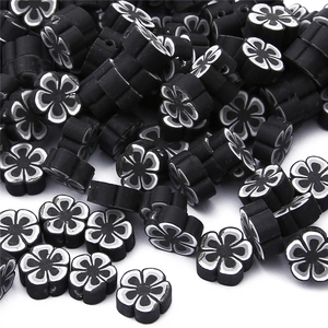 Détail des perles de fleurs en argile polymère noir et blanc pour bijoux artisanaux