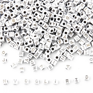 Close-up of 5x5mm white acrylic square letter beads with silver letters for DIY jewelry