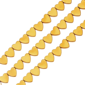 Macro detail of matte gold-plated heart-shaped beads for DIY jewelry making