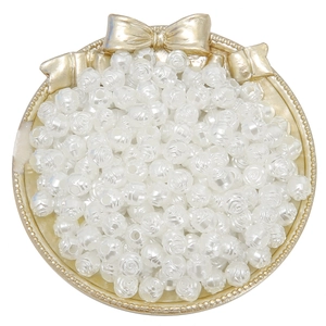 White acrylic rose pearl beads on a golden decorative tray for DIY jewelry making