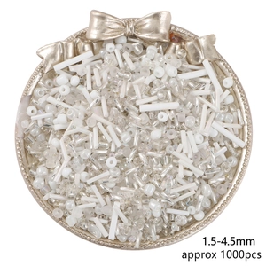 Assorted white and aurora glass seed beads for DIY jewelry making in a golden tray