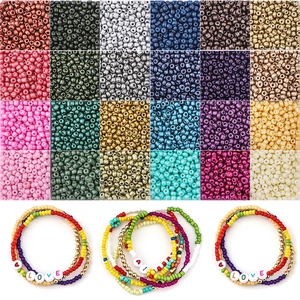 Vista macro di perline di vetro in 24 colori e perline con lettere per gioielli DIY