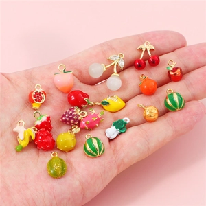 Macro shot of assorted colorful enamel fruit and vegetable pendants for DIY jewelry making