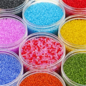 Vue détaillée de diverses perles de rocaille transparentes colorées en bocaux clairs