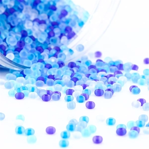 Mix of matte blue and purple seed beads pouring for DIY jewelry making and crafts