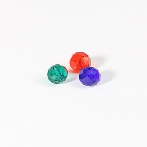 Macro shot of 8mm faceted crystal wheel beads in green, red, and blue for DIY jewelry