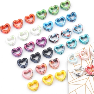 Flat lay macro of colorful marble texture hollow heart-shaped ceramic beads for DIY jewelry