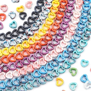 Close-up of heart-shaped ceramic beads with ink splatter pattern for DIY jewelry making