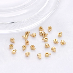 Bulk 18k gold plated DIY jewelry crimp beads and sliding clasps on white fabric