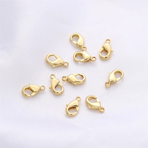 Dettaglio di nove chiusure a moschettone a cuore placcate in oro 14k per bigiotteria