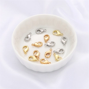 Dettaglio di chiusure a moschettone a cuore in oro 14k in finiture oro e argento