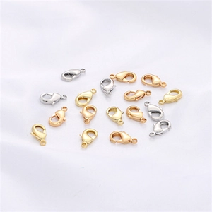 Macro di chiusure a moschettone a forma di cuore in oro e argento su tessuto di seta bianca
